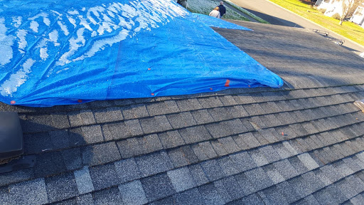 An emergency tarp as a roof is patched.