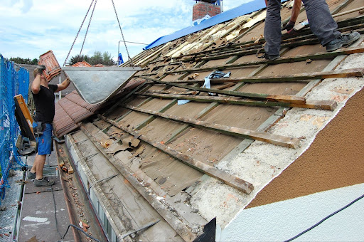Roofers tearing off an old roof