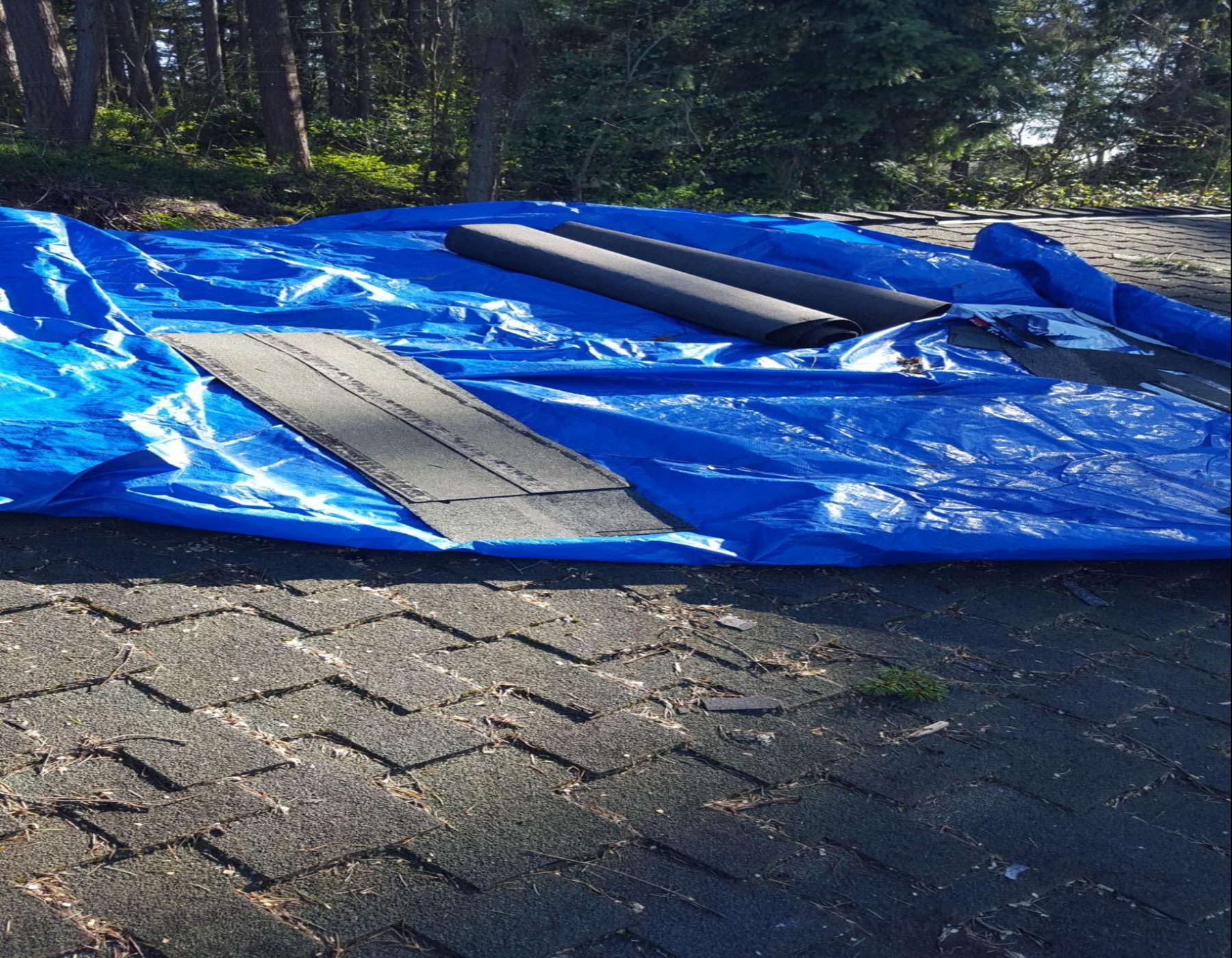 Emergency tarping on damaged roof.