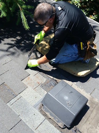 A roofer taking up tiles.