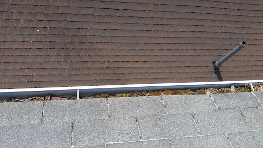 Old gutters being cleaned and replaced with new gutter guards.
