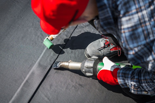 Roofers treating a roof.