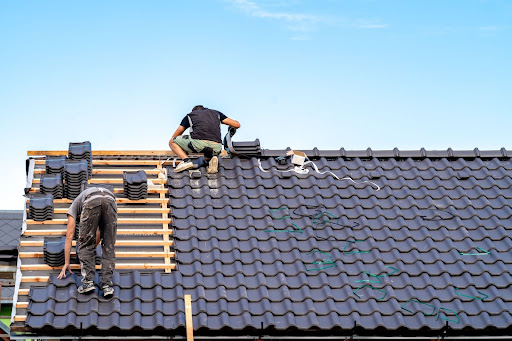 Two roofers working on a new roof.