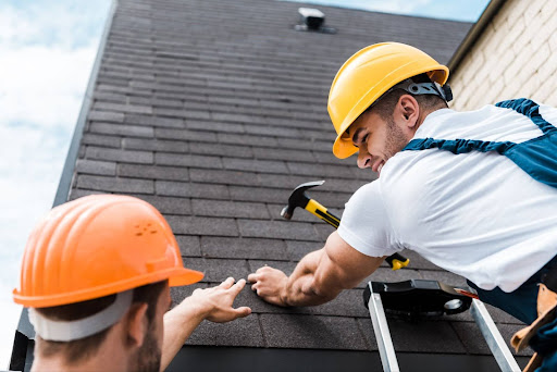 Two roofers working together.